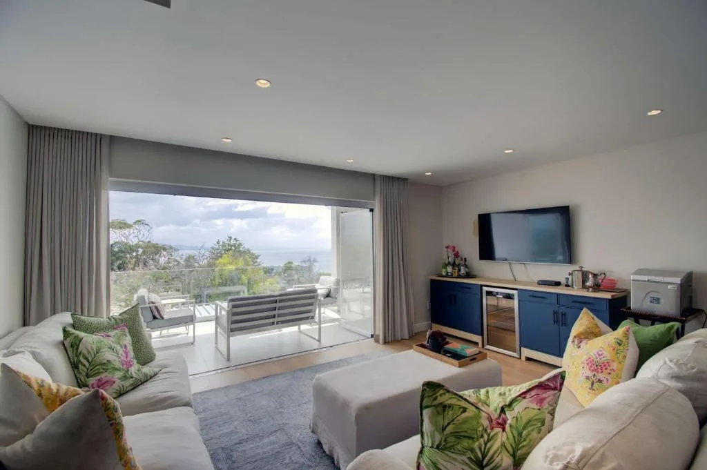 Modern lounge with coastal views, comfortable seating, and access to deck