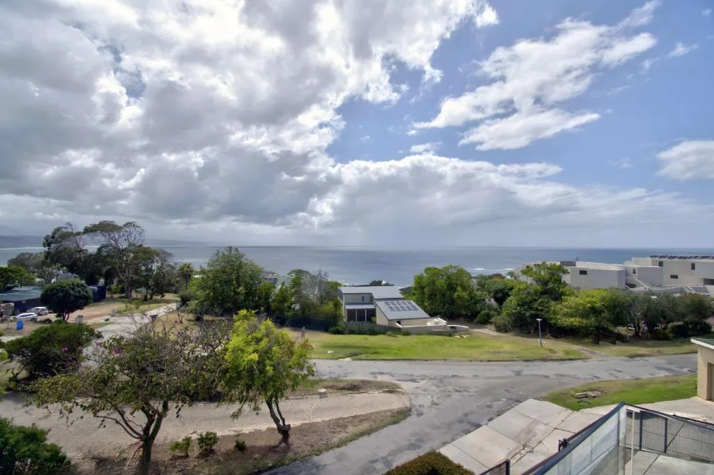 Ocean and lagoon vista with coastal properties and lush green landscape