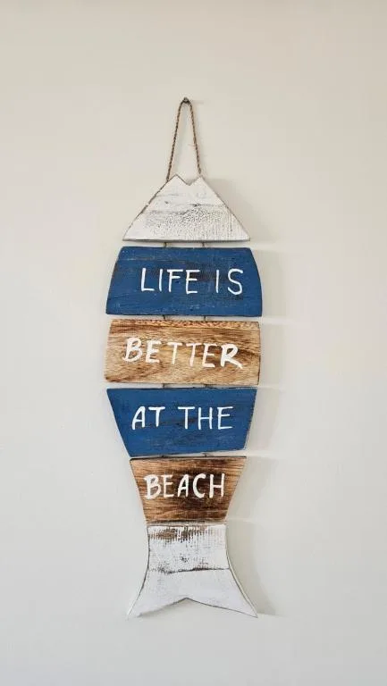 Wooden fish-shaped wall sign with beach-themed inspirational quote text