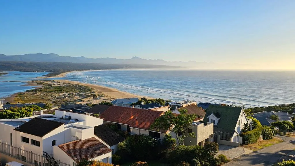 Coastal view of Plettenberg Bay with mountains and golden beach