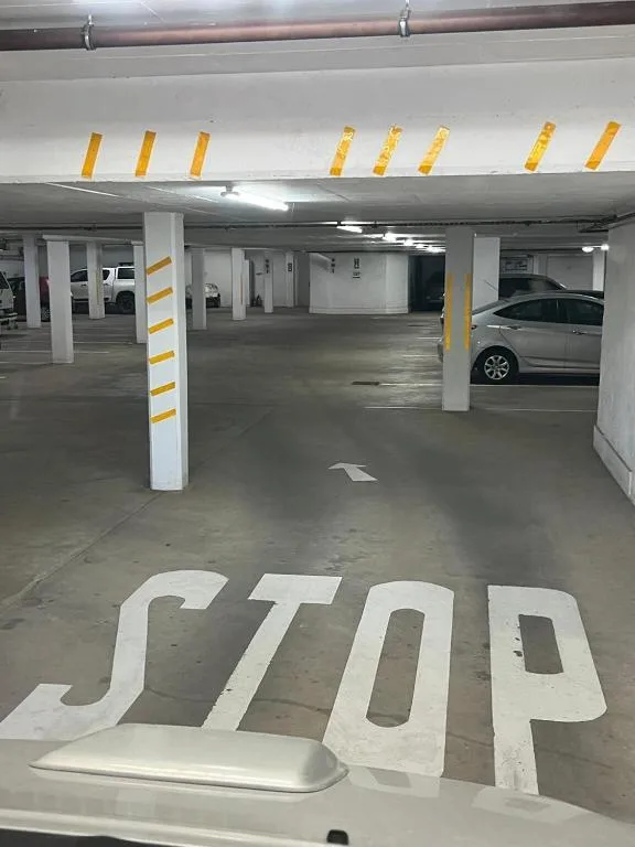 Underground parking garage with painted STOP marking and yellow safety stripes