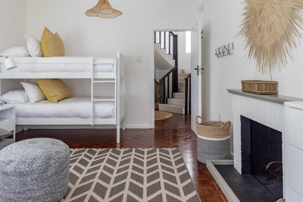 Bright bedroom with white bunk beds and yellow accent pillows