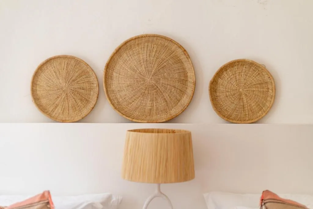 Three woven basket wall hangings and decorative lamp in bedroom decor