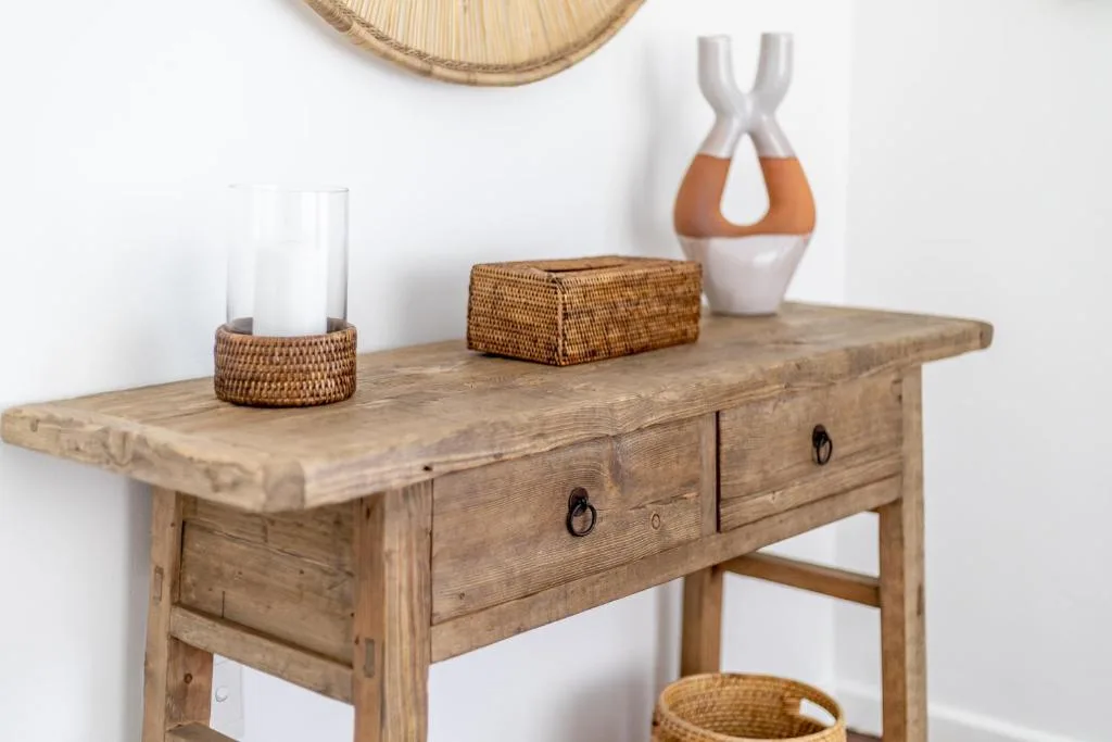 Rustic wooden console table with decorative baskets and ceramic vases