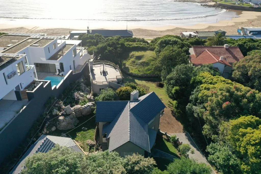 Aerial view of contemporary beach house with pool overlooking Plett beach and ocean