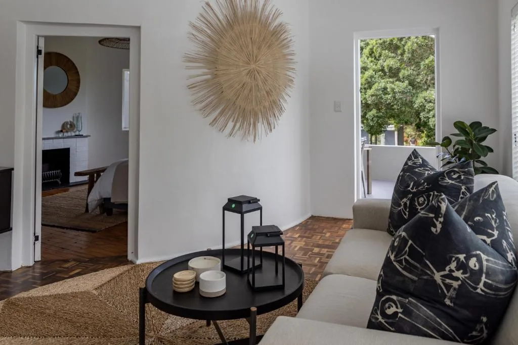 Bright lounge with neutral sofa, round black coffee table, and decorative wall art