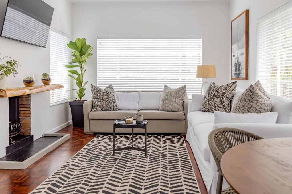 Bright lounge with cream sofa, patterned cushions, and modern fireplace