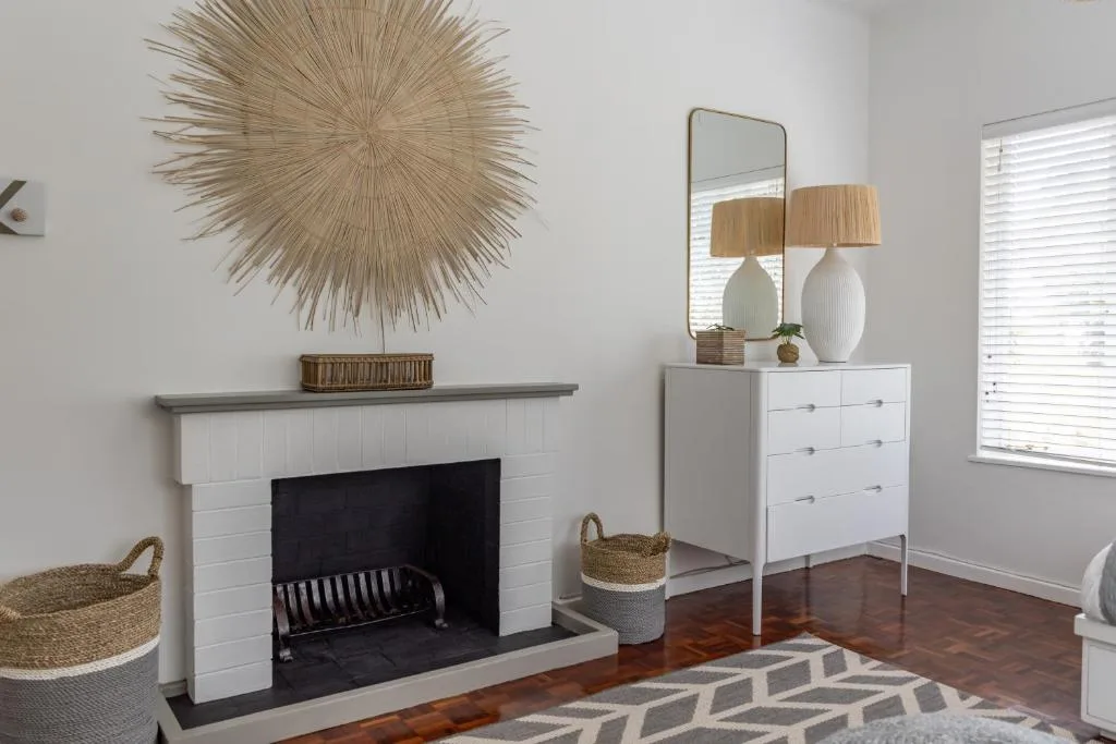 Modern lounge with white fireplace, wooden floors, and contemporary decor