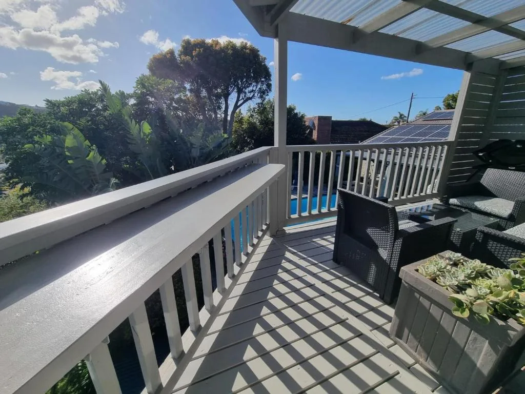 Spacious outdoor deck with white railings and garden views overlooking neighborhood