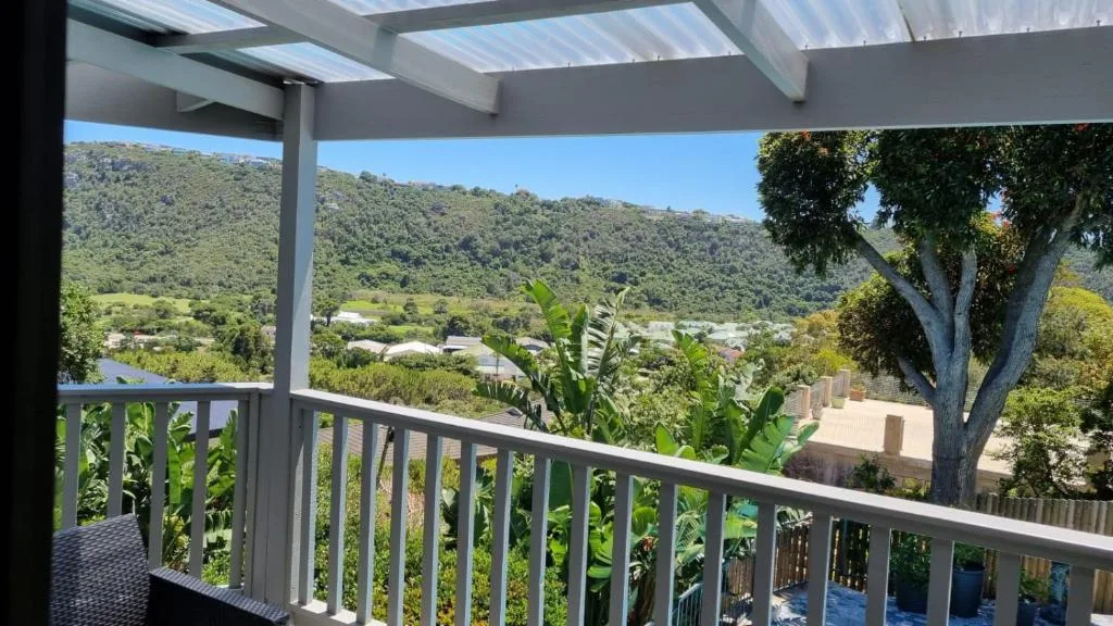 Covered deck with valley and mountain views, lush green landscape