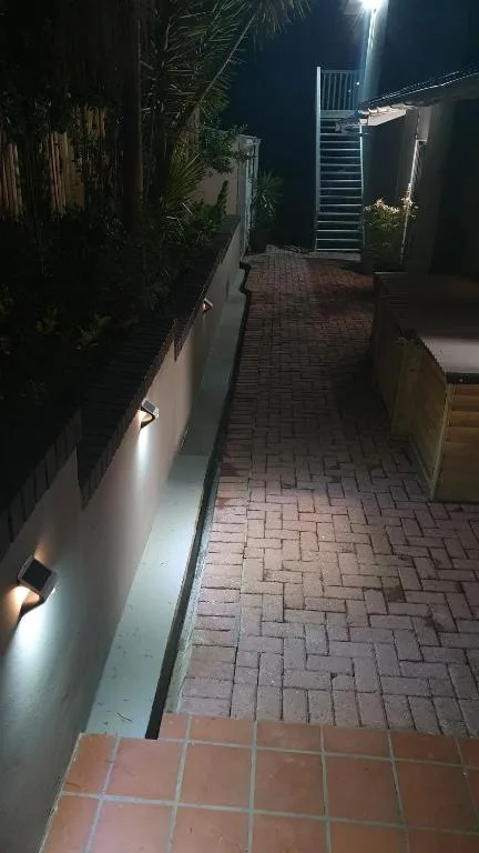 Night view of brick paved pathway leading to illuminated property entrance