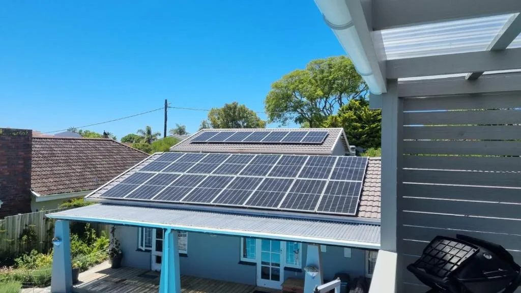 Modern white cottage with solar panels and blue trim entrance