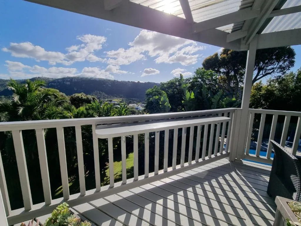 Mountain and valley landscape vista from shaded deck with white railings