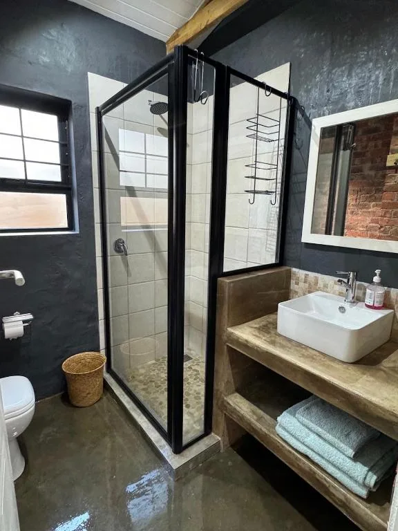 Modern bathroom with black framed shower enclosure and wooden vanity sink