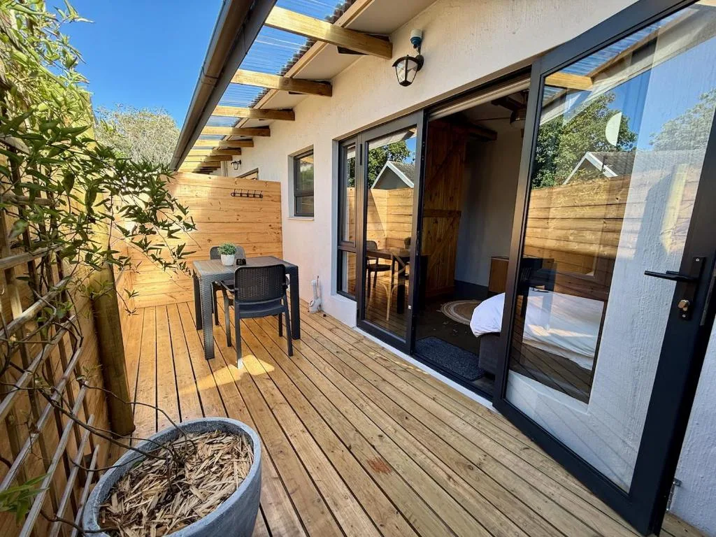 Wooden deck with seating area and garden views, modern apartment