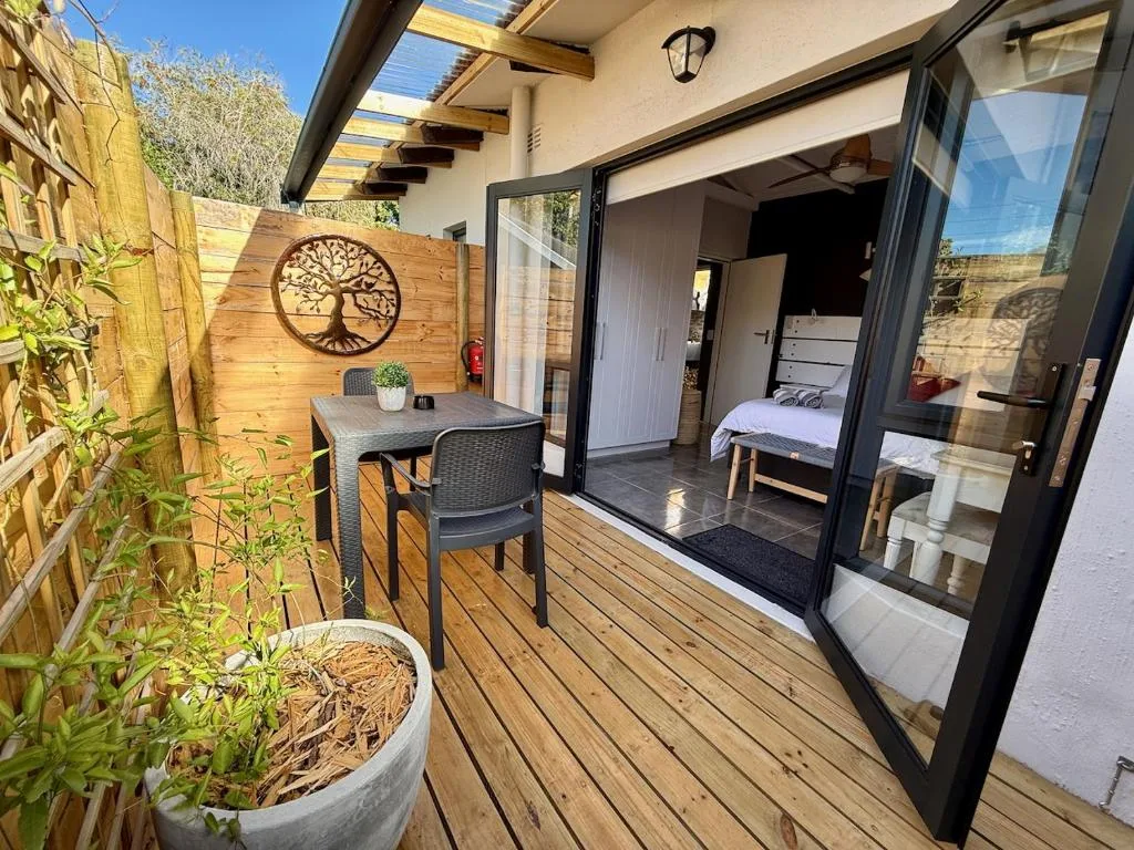 Wooden deck with outdoor seating table and access to bedroom
