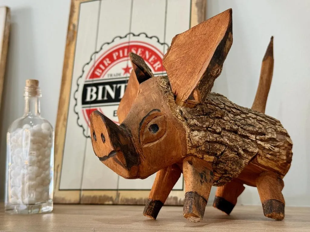 Wooden carved springbok figurine with beer signage and bottle backdrop