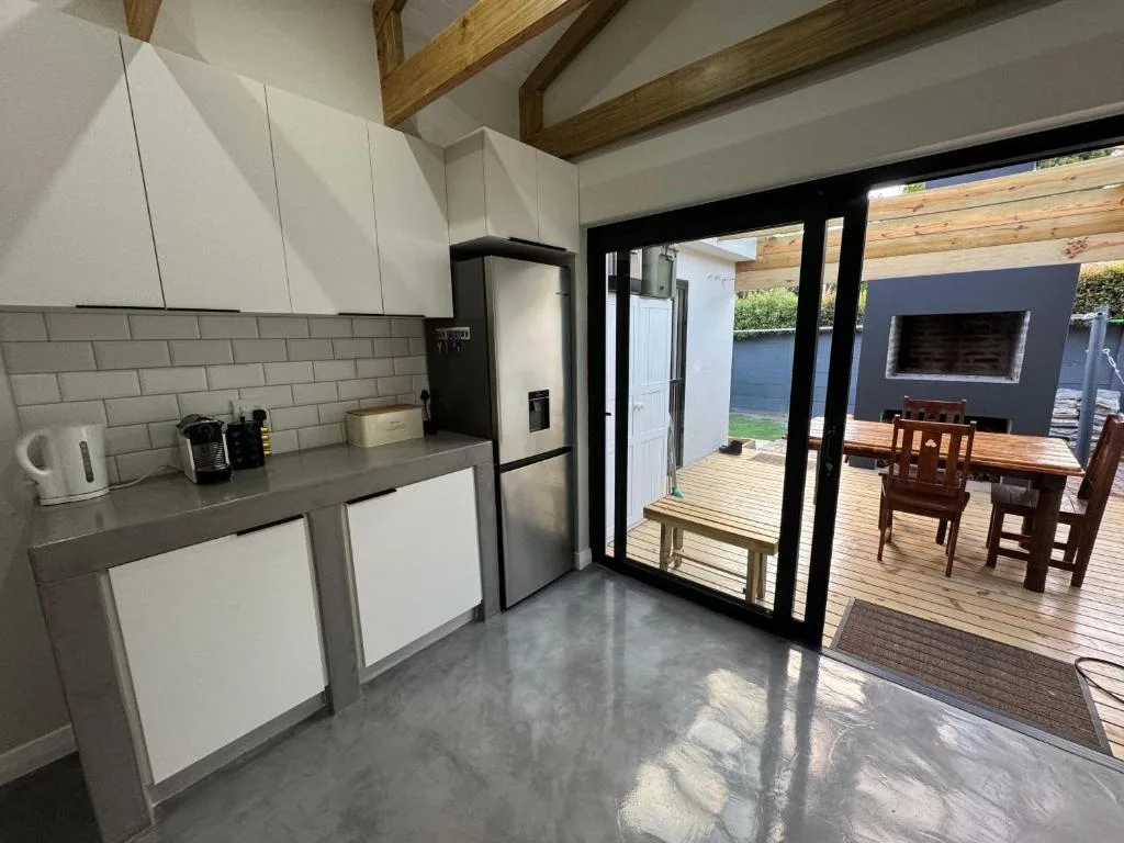 Modern kitchen with white cabinetry, subway tile backsplash, stainless steel appliances, and deck views