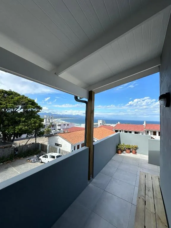 Modern covered deck with ocean and mountain views overlooking Plettenberg Bay