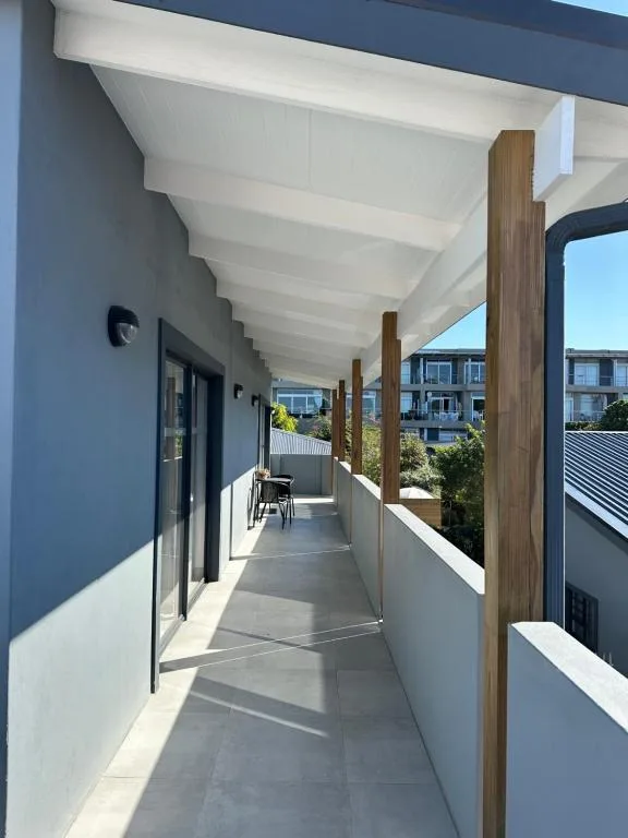 Modern covered deck with wooden posts and white ceiling beams