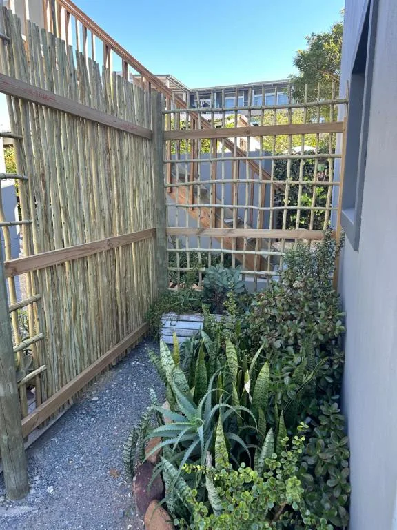 Narrow wooden deck with lush garden plants and mountain views