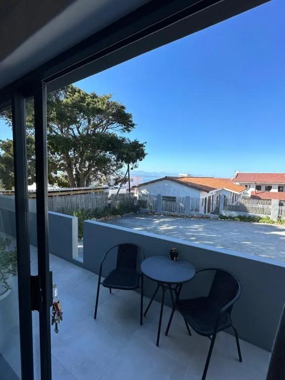 Modern balcony with seating overlooking Plettenberg Bay townscape and mountains