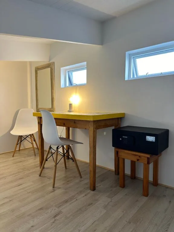 Compact workspace with wooden desk, modern chair, and small amplifier