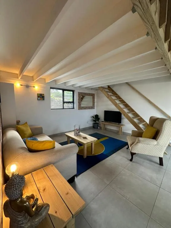 Modern loft lounge with sofa, armchair, TV, and contemporary furnishings