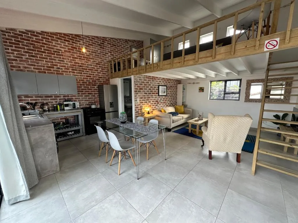 Open-plan living space with dining table, sofa, and brick feature wall