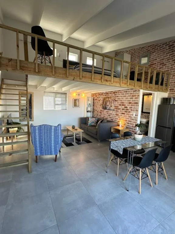 Open-plan lounge and dining area with exposed brick and mezzanine level