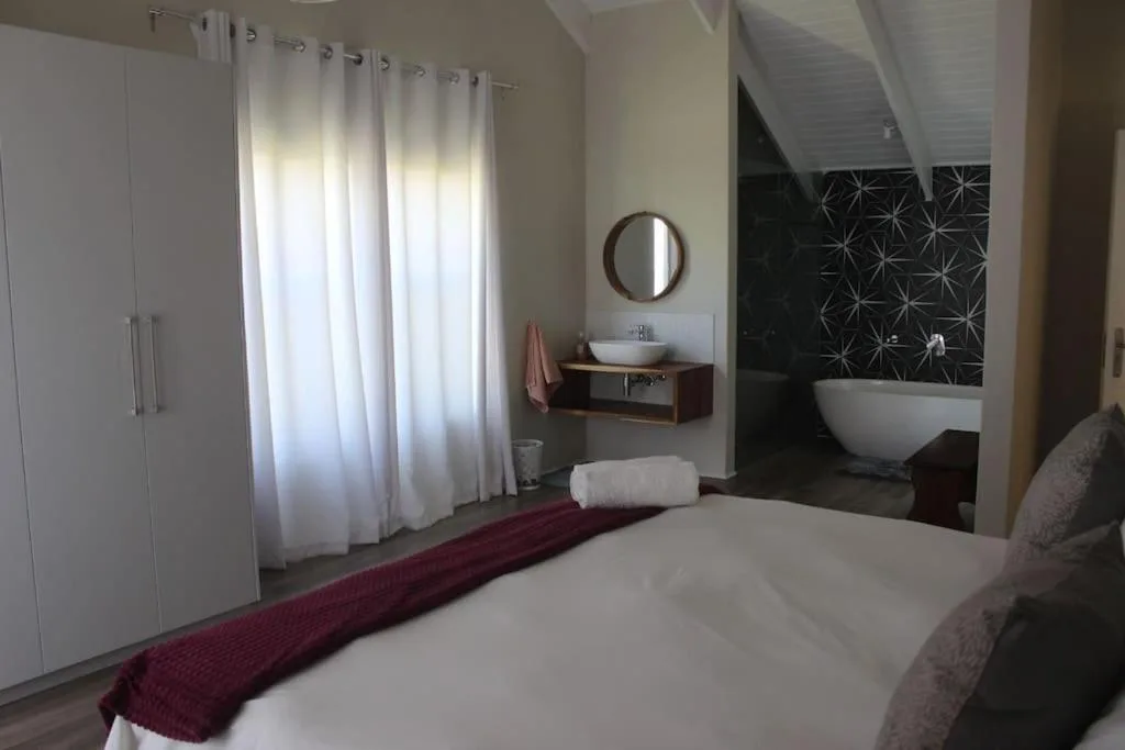 Spacious bedroom with ensuite bathroom, modern fixtures, and natural light