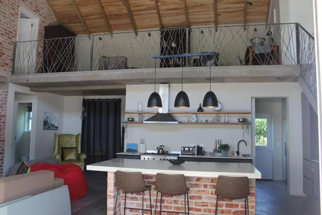 Modern kitchen with black pendant lights, white counters, and dining island seating