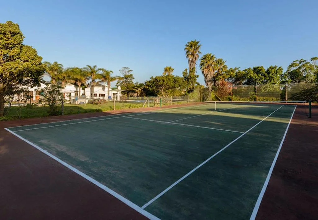 Tennis courts on the property grounds with tropical garden surroundings