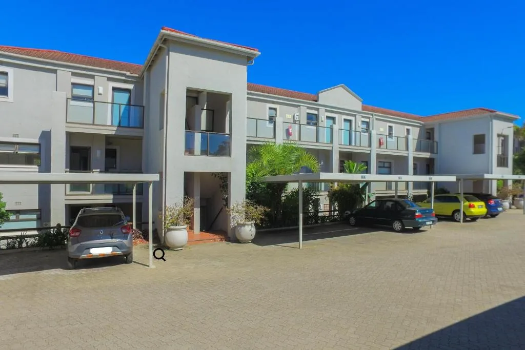 Modern white apartment building with carport and driveway in Plettenberg Bay