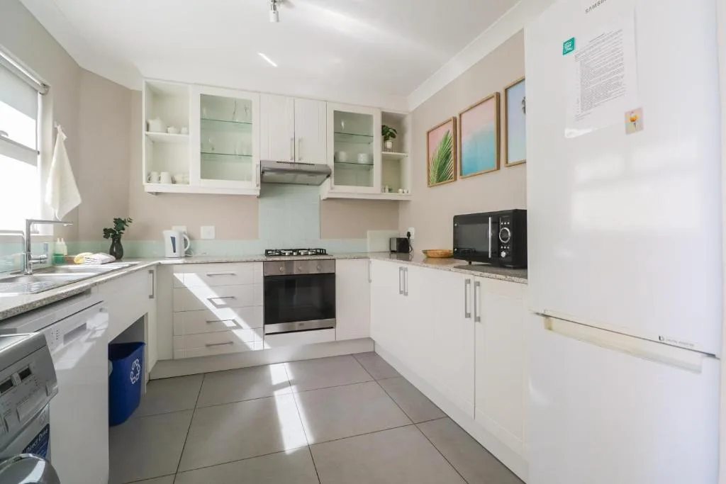 Modern white kitchen with gas stove, dishwasher, and ample cabinetry