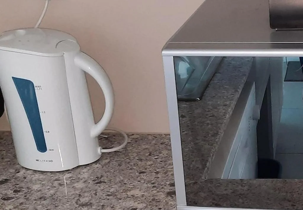 Kitchen counter with electric kettle and stainless steel appliance