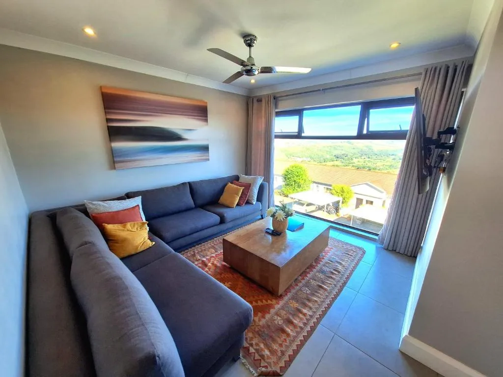 Modern lounge with blue sofas overlooking scenic valley landscape