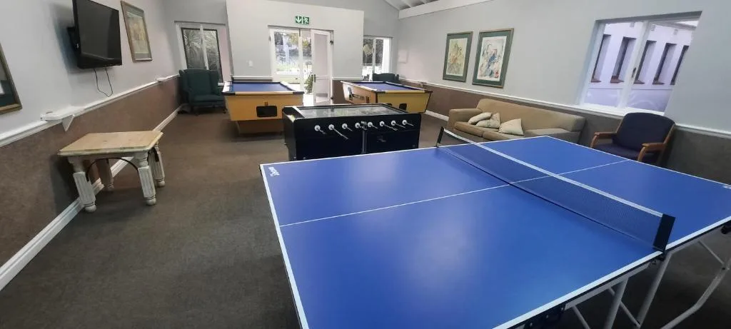 Games room with ping pong table, pool tables, and seating areas