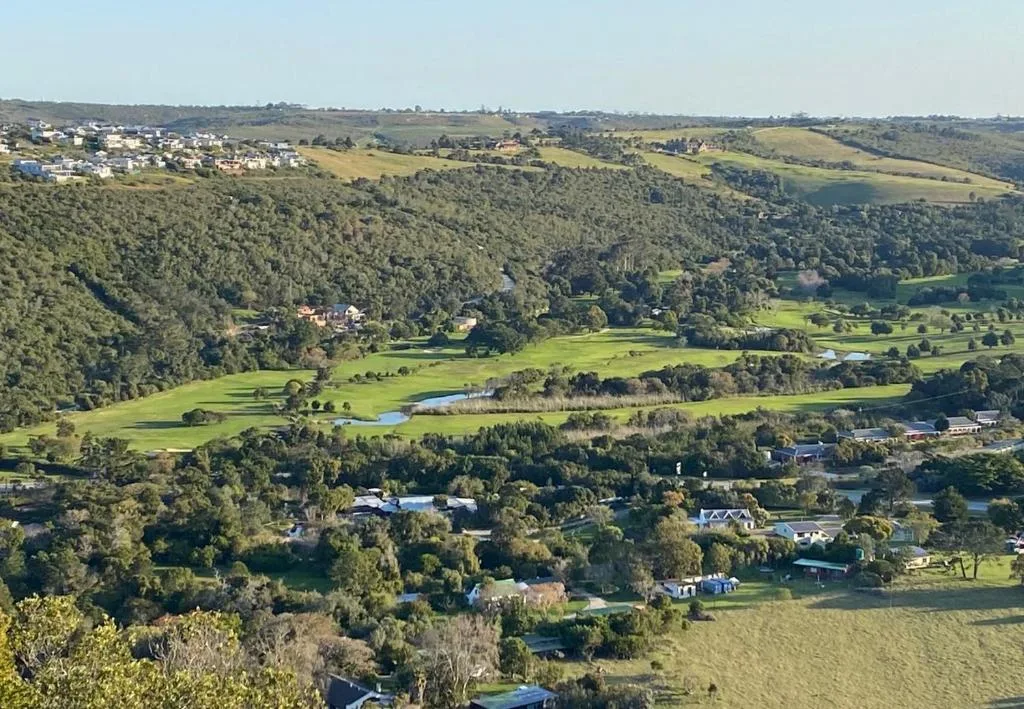 Sweeping valley landscape with forests, farmland, and scattered homes below