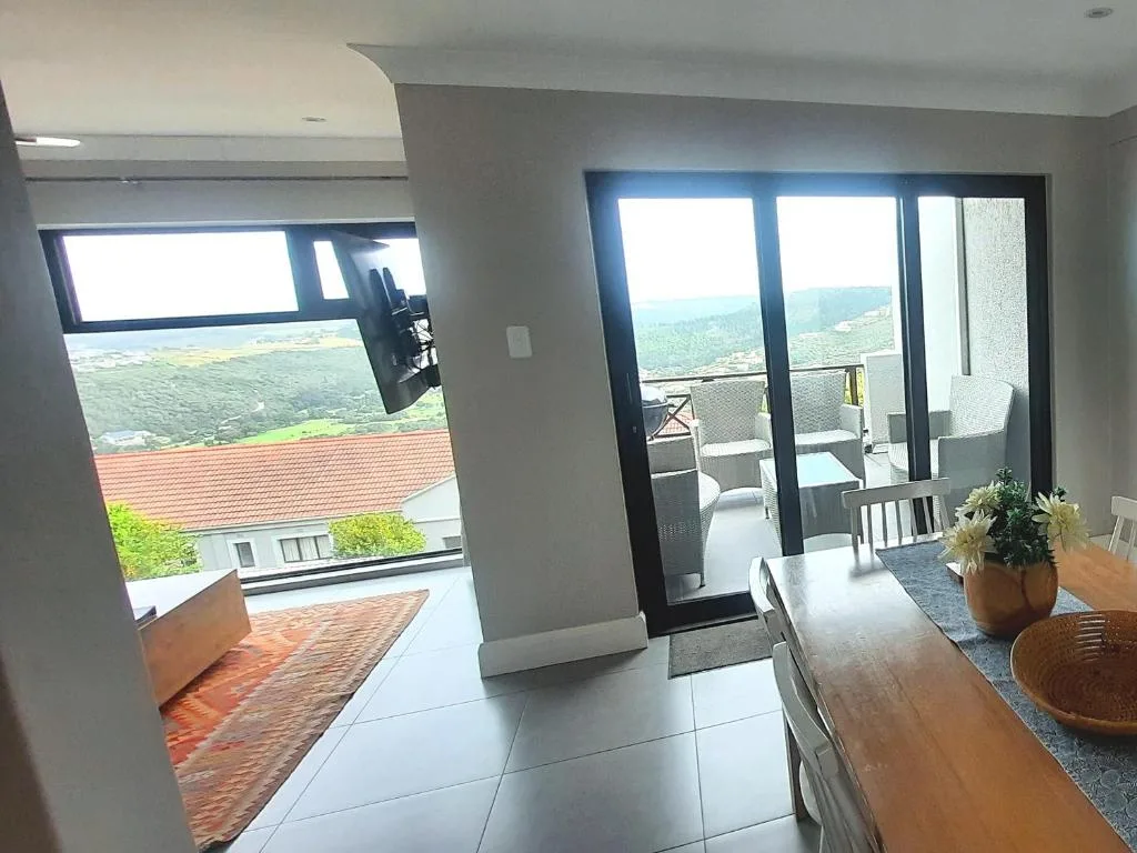 Scenic forested valley and hills visible through large glass doors