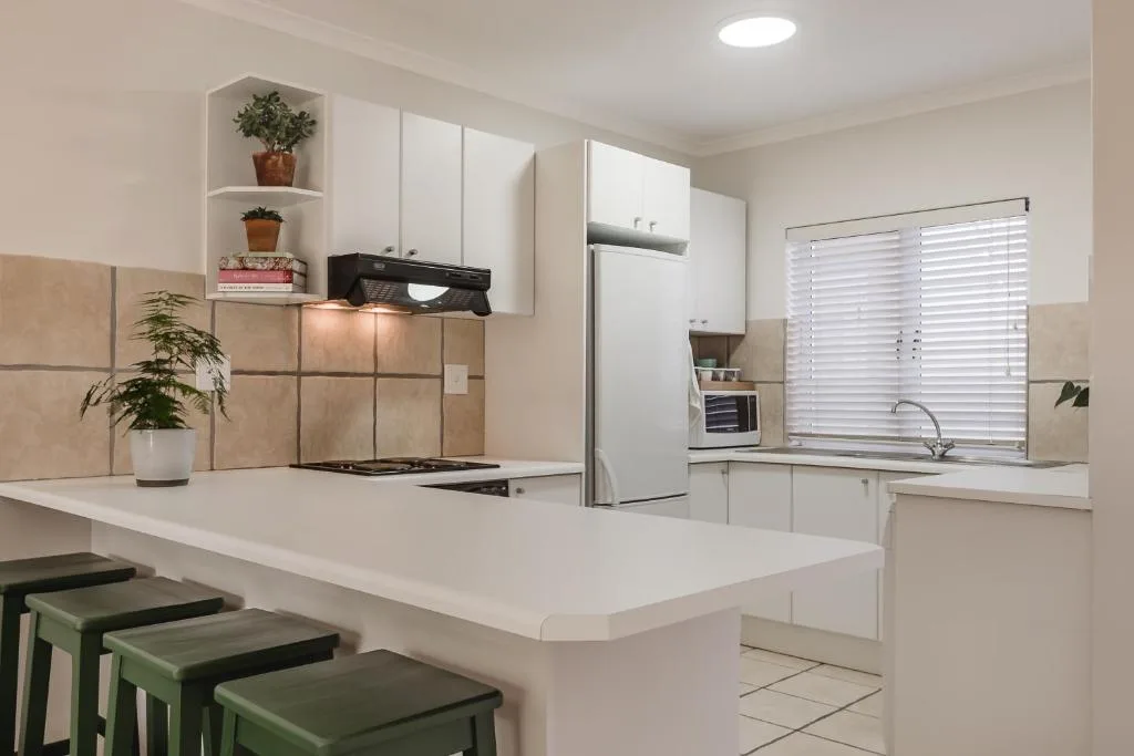 Modern kitchen with white cabinetry, stainless steel appliances, and island seating