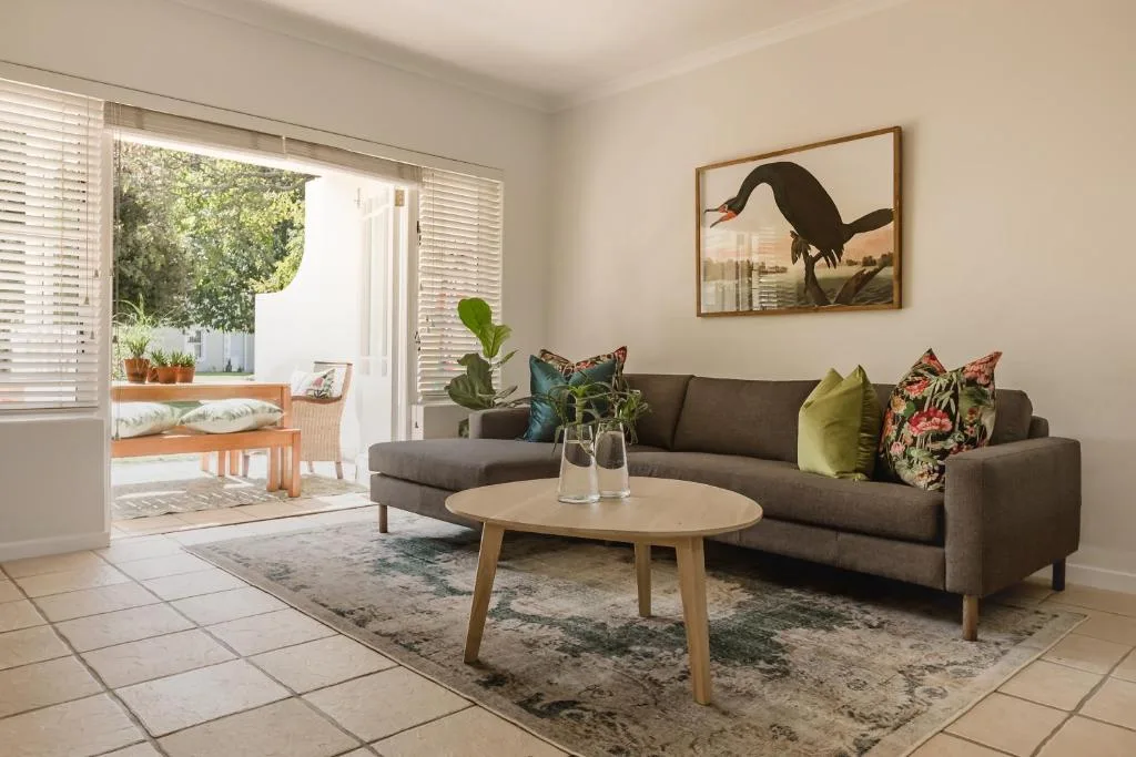Contemporary lounge with gray sofa, wooden coffee table, and garden view through sliding doors