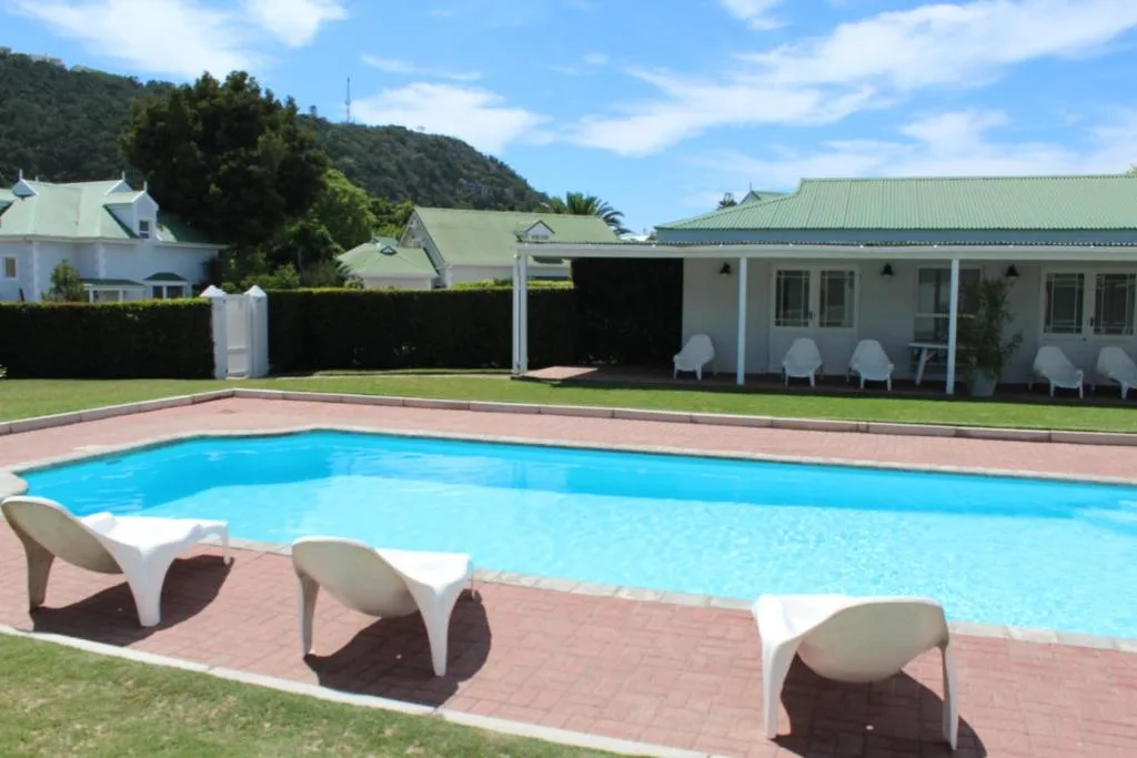 Sparkling swimming pool with loungers and mountain views behind