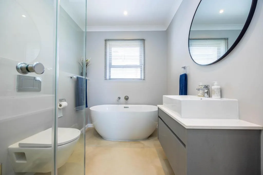 Modern bathroom with freestanding tub, dual vanity, and walk-in shower