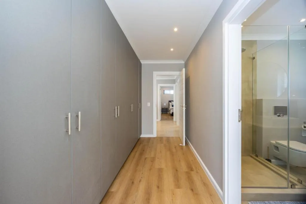 Modern hallway with built-in wardrobes and ensuite bathroom access