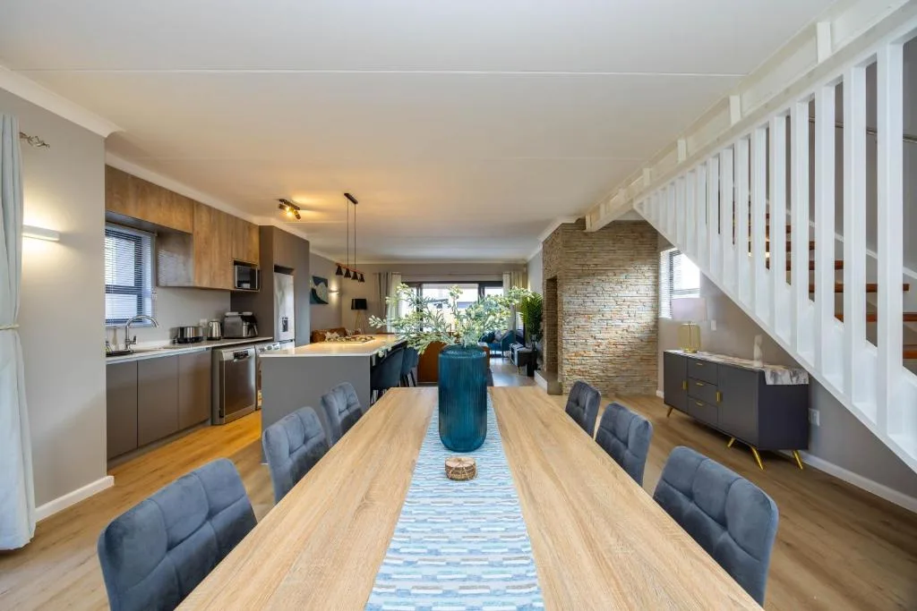 Open-plan dining area with wooden table and blue upholstered chairs