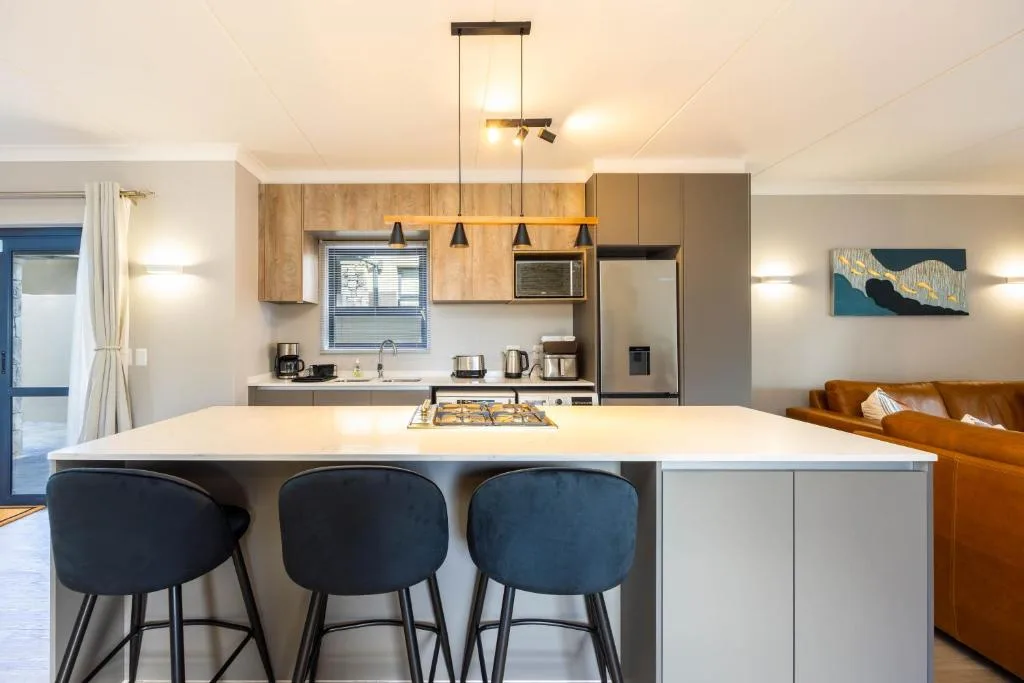 Modern kitchen with island seating, stainless steel appliances, pendant lighting