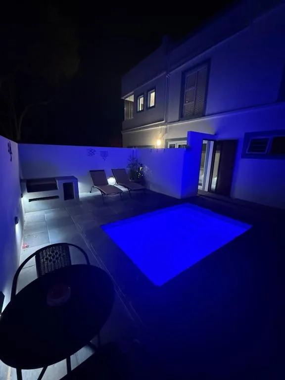 Illuminated patio area with blue mood lighting and outdoor seating furniture