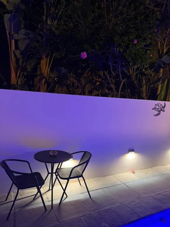 Evening deck with seating table, garden backdrop, atmospheric lighting