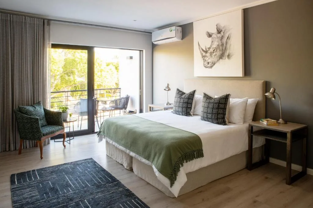 Spacious bedroom with queen bed, deck access, and garden views